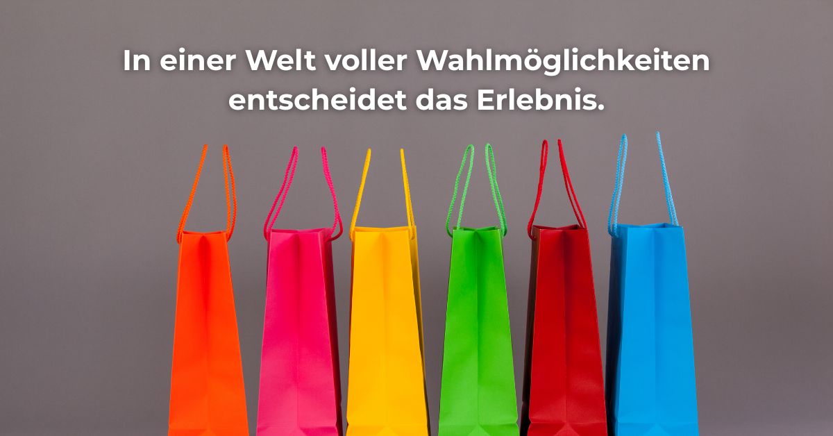 Bunte Einkaufstaschen vor grauem Hintergrund als Metapher für Differenzierung durch Customer Experience im digitalen Zeitalter