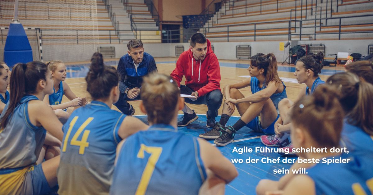 Basketball-Coach spricht im Kreis mit seinem Team – Sinnbild für agile Führung, Delegation und die Rolle der Führungskraft als Coach statt Spieler.