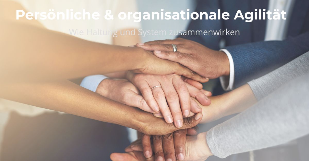 Symbolbild für persönliche und organisationale Agilität – Menschen legen vertrauensvoll ihre Hände übereinander.