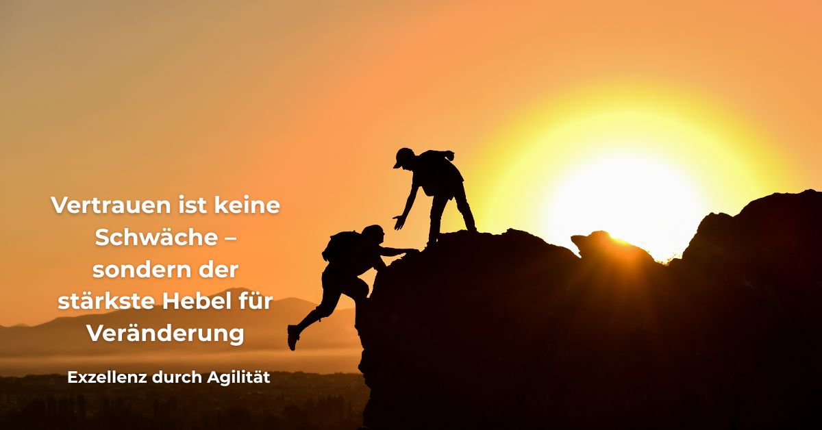 Zwei Menschen bei Sonnenaufgang, einer hilft dem anderen beim Aufstieg auf einen Felsen – mit Zitat: „Vertrauen ist keine Schwäche – sondern der stärkste Hebel für Veränderung.“ – Exzellenz durch Agilität